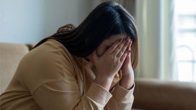 امرأة تغطي وجهها بكفيها