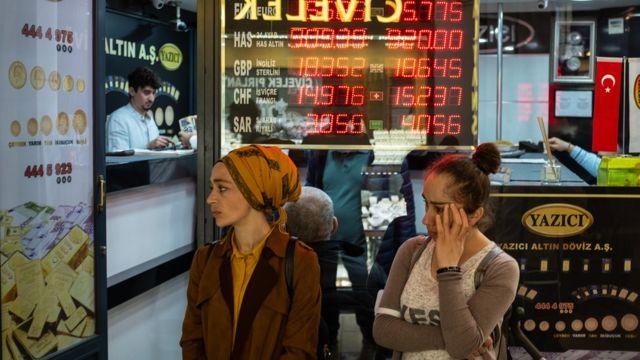 People stand next to a currency exchange office at Istanbul's Grand Bazaar on May 05, 2022 in Istanbul, Turkey. Inflation soared to nearly 70% (69.97%) over one year in April in Turkey, the highest since February 2002, according to official figures released on May 5.