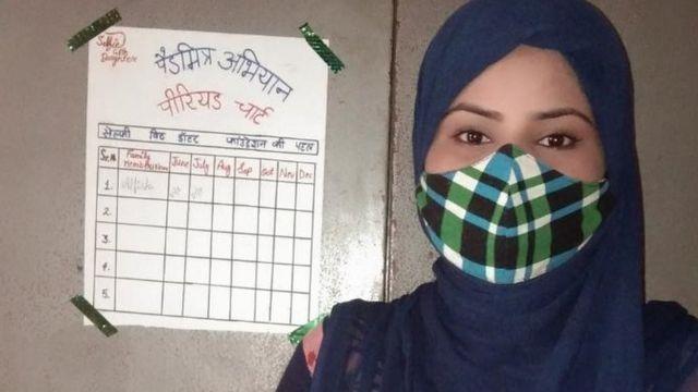 ألفيشان تقف إلى جانب الجدول الزمني الخاص بمواعيد دورتها الشهرية الملصق على الباب