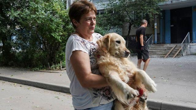 امرأة تحمل كلبها