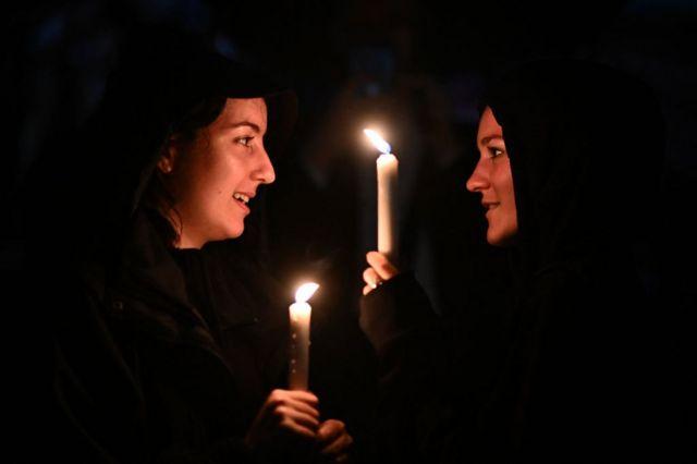 نساء يحملن الشموع أمام قصر باكنغهام