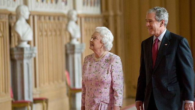 ملكة بريطانيا إليزابيث الثانية (إلى اليسار) تقوم بجولة في قاعة سانت جورج إلى الرئيس الأمريكي جورج دبليو بوش في قلعة وندسور، في وندسور، بيركشاير، غرب لندن، في 15 يونيو/ حزيران 2008.