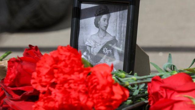 زهور بجوار صورة للملكة إليزابيث